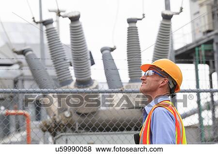 Stock Photo - Electrical engineer examining transformers. Fotosearch
