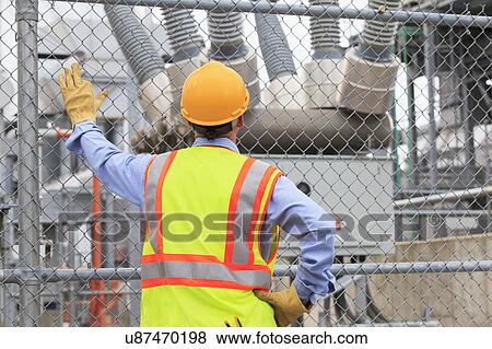 Stock Photo - Electrical engineer examining transformers. Fotosearch