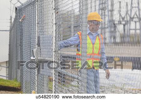 Stock Image - Electrical engineer using security system. Fotosearch