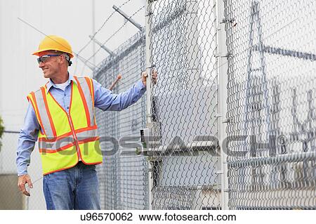Stock Image - Electrical engineer using security system. Fotosearch