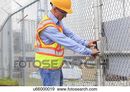 Stock Photo - Electrical engineer using security system. Fotosearch
