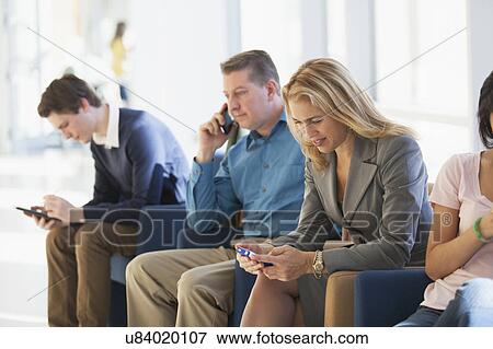 Stock Photo - Passengers seated in an airport lounge. Fotosearch