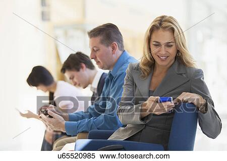 Stock Photography - Passengers seated in an airport lounge. Fotosearch