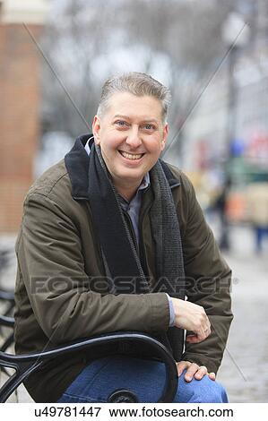 Stock Photo - Portrait of a man sitting on a bench. Fotosearch