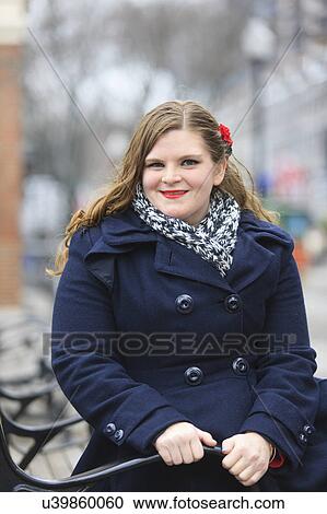 Stock Image - Portrait of a woman sitting on a bench. Fotosearch