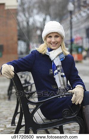 Portrait of a woman sitting on a bench View Large Photo Image Stock Image - Portrait of a woman sitting on a bench. Fotosearch