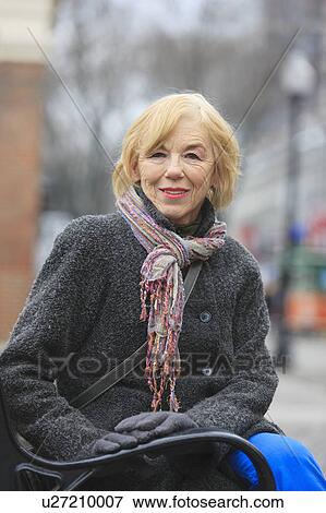 Portrait of a woman sitting on a bench View Large Photo Image Stock Photo - Portrait of a woman sitting on a bench. Fotosearch