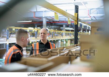 Apprentice and mentor in parts store in car factory View Large Photo Image Stock Photo - Apprentice and mentor in parts store in car factory. Fotosearch