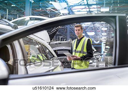 Picture - Apprentice car inspector in car factory, portrait. Fotosearch