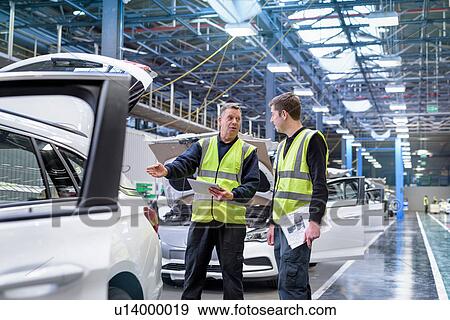 Stock Photo - Apprentice car inspector with mentor in car factory. Fotosearch