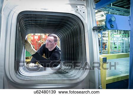 Apprentice engineer inspector inspecting body panels of vehicle in car factory View Large Photo Image Stock Photo - Apprentice engineer inspector inspecting body panels of vehicle in car factory. Fotosearch