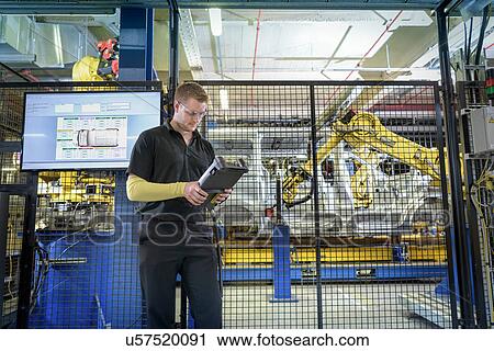 Apprentice engineer operating robots on production line in car factory View Large Photo Image Stock Image - Apprentice engineer operating robots on production line in car factory. Fotosearch