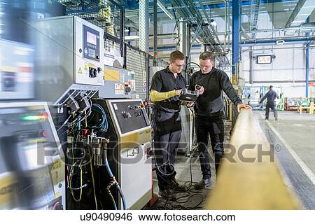 Apprentice engineers on production line in car factory View Large Photo Image Stock Photograph - Apprentice engineers on production line in car factory. Fotosearch
