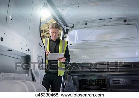 Stock Photography - Apprentice vehicle inspector inspecting interior of vehicle in car factory. Fotosearch
