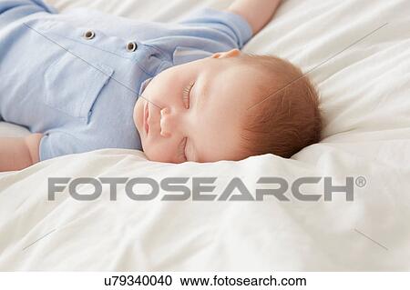 Baby boy lying on bed asleep View Large Photo Image Stock Image - Baby boy lying on bed asleep. Fotosearch