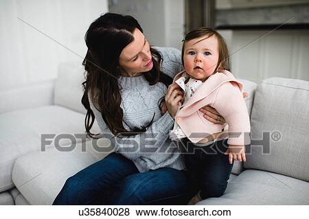 Baby girl looking up while being snuggled by her mother View Large Photo Image Stock Photo - Baby girl looking up while being snuggled by her mother. Fotosearch