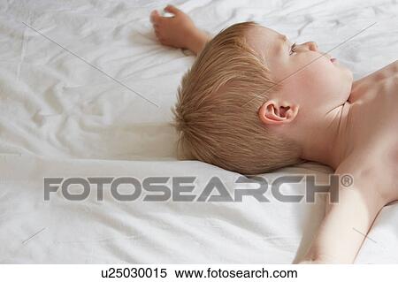 Bare-chested boy lying on bed daydreaming View Large Photo Image Stock Photography - Bare-chested boy lying on bed daydreaming. Fotosearch