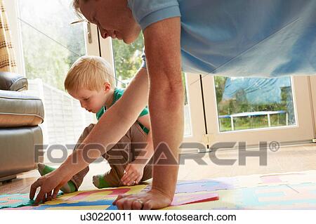 Boy and father playing with floor jigsaw puzzle View Large Photo Image Stock Image - Boy and father playing with floor jigsaw puzzle. Fotosearch