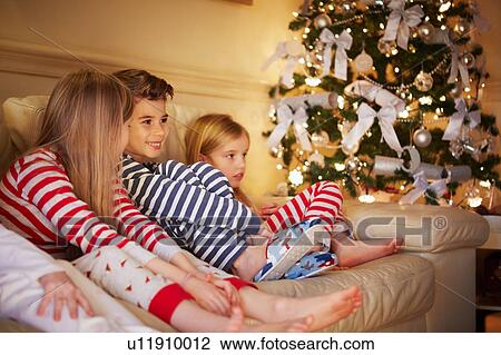 Boy and girls in striped pyjamas on sofa at christmas View Large Photo Image Stock Image - Boy and girls in striped pyjamas on sofa at christmas. Fotosearch