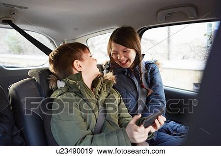 Boy and sister laughing in car backseat View Large Photo Image Stock Photo - Boy and sister laughing in car backseat. Fotosearch