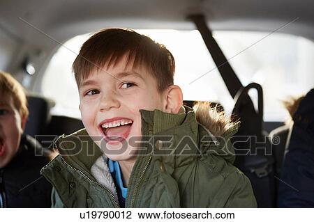 Boy laughing in car backseat View Large Photo Image Stock Image - Boy laughing in car backseat. Fotosearch