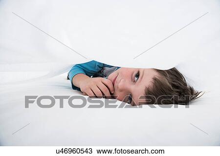 Boy lying between white bed sheets View Large Photo Image Stock Image - Boy lying between white bed sheets. Fotosearch