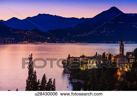 Buildings illuminated at sunset by Lake Como, Varenna, Italy View Large Photo Image Stock Photograph - Buildings illuminated at sunset by Lake Como, Varenna, Italy. Fotosearch