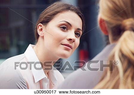 Stock Photo - Business women having discussion. Fotosearch