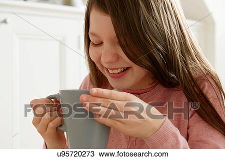 Stock Image - Close up of girl holding coffee cup. Fotosearch