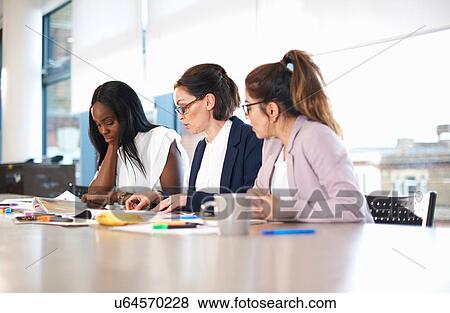 Colleagues having meeting at conference room table View Large Photo Image Stock Photo - Colleagues having meeting at conference room table. Fotosearch