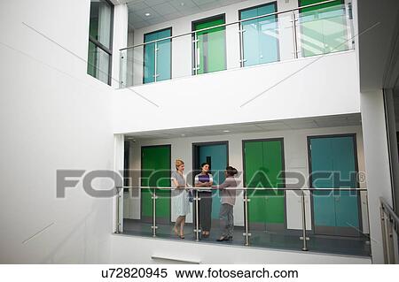 Colleagues on balcony in office building View Large Photo Image Stock Photography - Colleagues on balcony in office building. Fotosearch