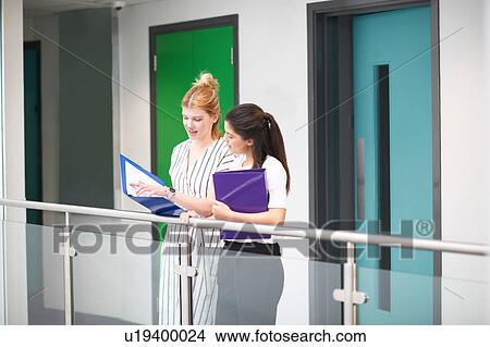 Picture - Colleagues with paperwork in files in office building. Fotosearch