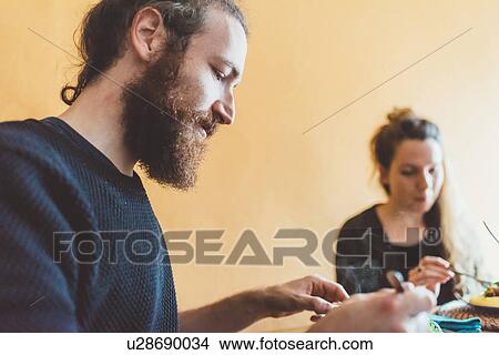Picture - Couple eating lunch at kitchen table. Fotosearch