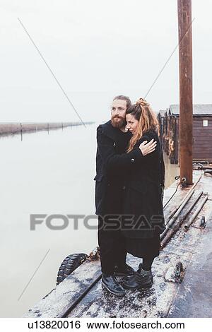 Couple hugging on misty canal waterfront View Large Photo Image Stock Photograph - Couple hugging on misty canal waterfront. Fotosearch