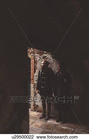 Stock Image - Couple looking out from darkened doorway, Venice, Italy. Fotosearch
