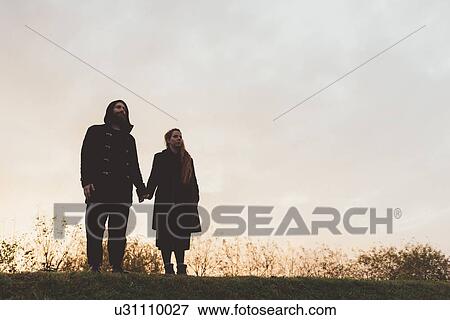 Couple looking out from embankment at dusk View Large Photo Image Stock Photo - Couple looking out from embankment at dusk. Fotosearch