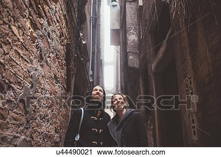 Couple looking up from alley, Venice, Italy View Large Photo Image Stock Image - Couple looking up from alley, Venice, Italy. Fotosearch