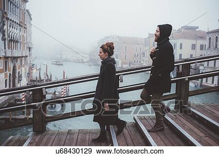 Couple moving down stairway over misty canal, Venice, Italy View Large Photo Image Stock Photo - Couple moving down stairway over misty canal, Venice, Italy. Fotosearch
