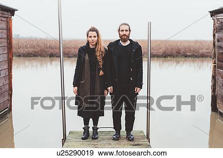Couple standing at edge of canal pier View Large Photo Image Stock Photo - Couple standing at edge of canal pier. Fotosearch