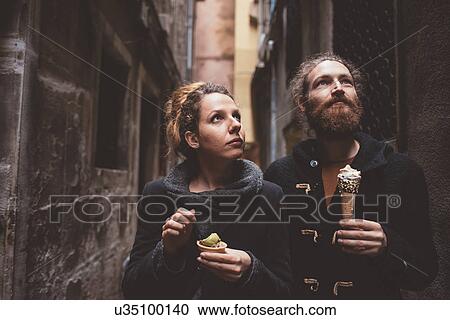 Stock Image - Couple with gelato in dark alley, Venice, Italy. Fotosearch
