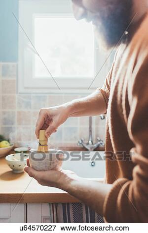 Stock Photo - Cropped shot of man stirring bowl in kitchen. Fotosearch