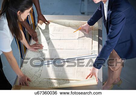 Cropped view of colleagues in office looking at blueprint View Large Photo Image Stock Photograph - Cropped view of colleagues in office looking at blueprint. Fotosearch