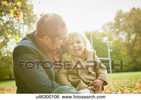 Daughter sitting on father's lap smiling View Large Photo Image Stock Photograph - Daughter sitting on father's lap smiling. Fotosearch