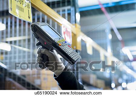 Picture - Detail of scanner being used in parts store of car factory. Fotosearch