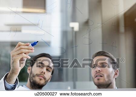 Stock Photo - Doctor meeting with consultant, writing on glass whiteboard. Fotosearch
