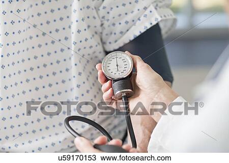 Doctor taking patient's blood pressure View Large Photo Image Stock Image - Doctor taking patient's blood pressure. Fotosearch