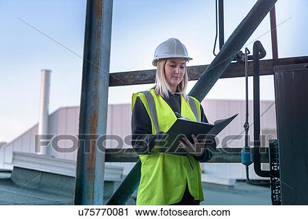 Stock Image - Ecologist taking notes in car plant. Fotosearch