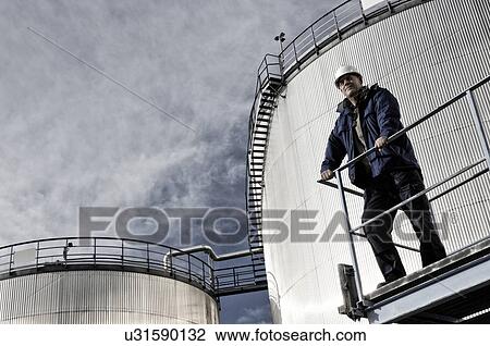 Engineer with oil storage towers View Large Photo Image Stock Image - Engineer with oil storage towers. Fotosearch
