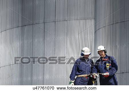 Engineers by oil storage tower View Large Photo Image Stock Image - Engineers by oil storage tower. Fotosearch