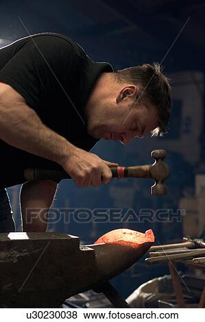 Farrier forging horseshoe on anvil View Large Photo Image Stock Photo - Farrier forging horseshoe on anvil. Fotosearch